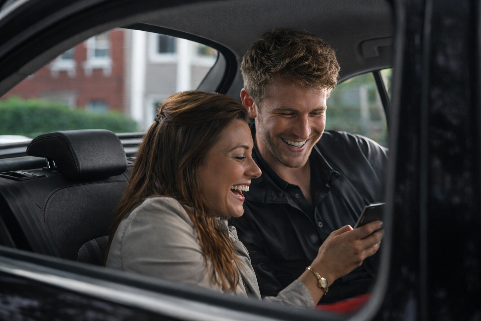 Two happy passengers in the backseat of a car